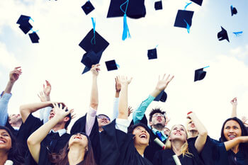 Absolventen werfen ihre Hüte